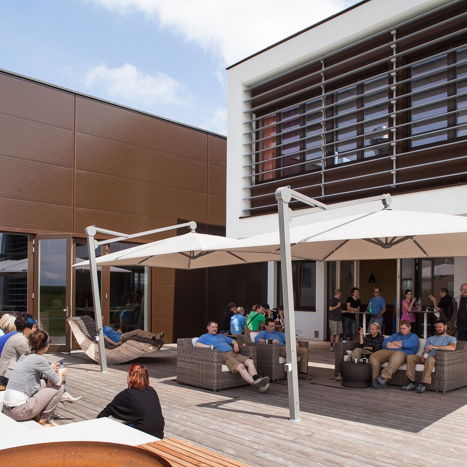 Terrasse der Tischlerei Krumböck mit Mitarbeiter:innen an einem sonnigen Nachmittag