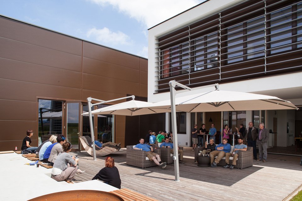 Terrasse der Tischlerei Krumböck mit Mitarbeiter:innen an einem sonnigen Nachmittag