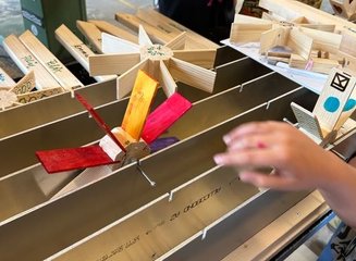 Wasserräder aus Holz werden in einer Metallschiene getestet Ferienabenteuer in der Tischlerei