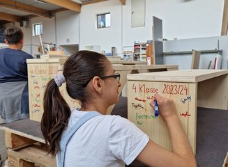 Schülerin beim Beschriften einer Bank Volksschule Gerersdorf zu Besuch