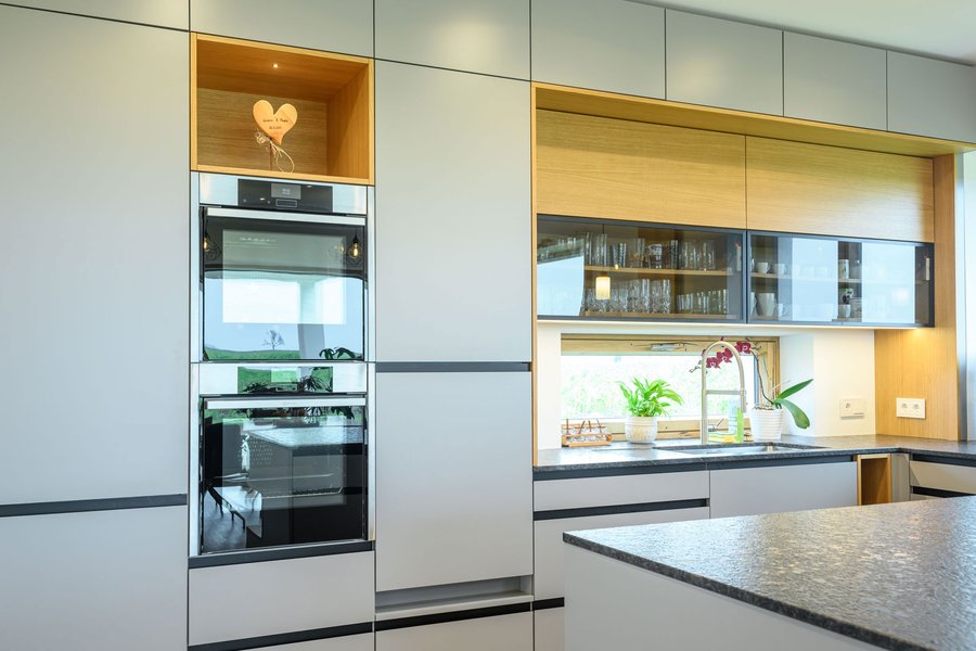 © Wolfgang Stecher/grapple.at Küche in grau mit Holzelementen und eingebautem Herd