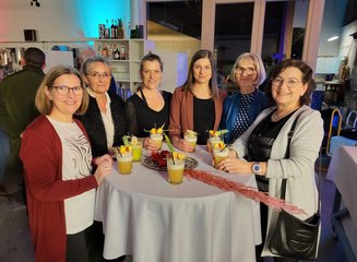 Entspannte Stimmung der Mitarbeiterinnen bei einem gemeinsamen Getränk Weihnachtsfeier 2024