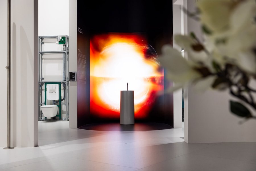 Hohes Waschbecken vor digitaler Wand mit roten Effekten auf einem Messestand
