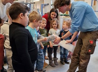 Kinder erkunden die unterschiedlichen Holzarten mit Mitarbeiter der Tischlerei Krumböck Kindergarten Gerersdorf zu Besuch