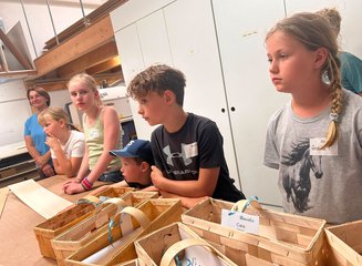 Kinder beim Bearbeiten von Holz in einer Tischlerei Ferienspass 2026: Kleine Werkstücke, große Begeisterung