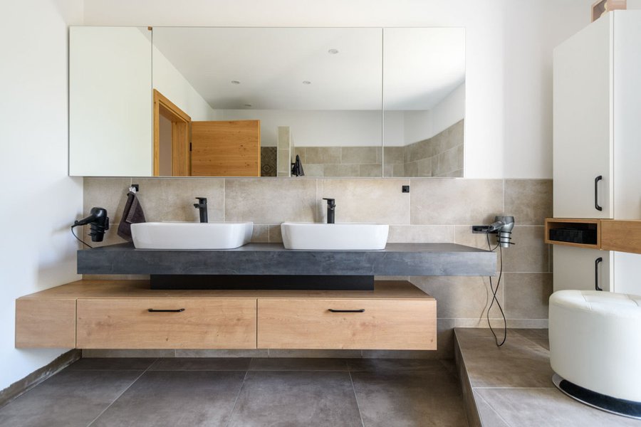 Badezimmer mti zwei Waschbecken und großem Spiegel darüber