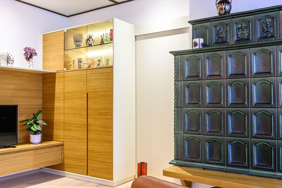 © Wolfgang Stecher/grapple.at Wohnzimmer mit Wohnzimmerverbau aus Holz und mit grünem Kachelofen