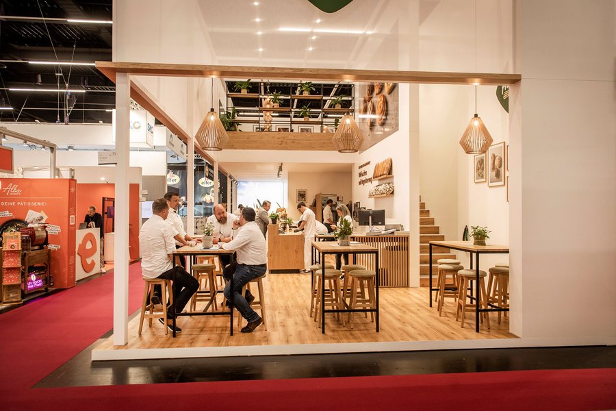 © Stefan Knittl Offener Messestand mit Hochtischen und Menschen