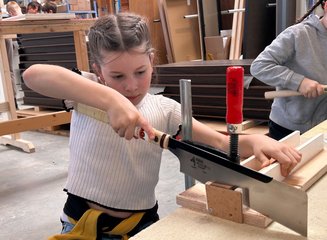 Kind beim Schneiden von Holz Handwerklicher Besuch der Volksschule Hafnerbach