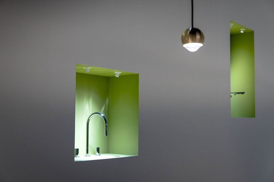 © Kim Culetto Aussparrungen an der Außenwand des Messestandes mit platzierten Wasserhähnen