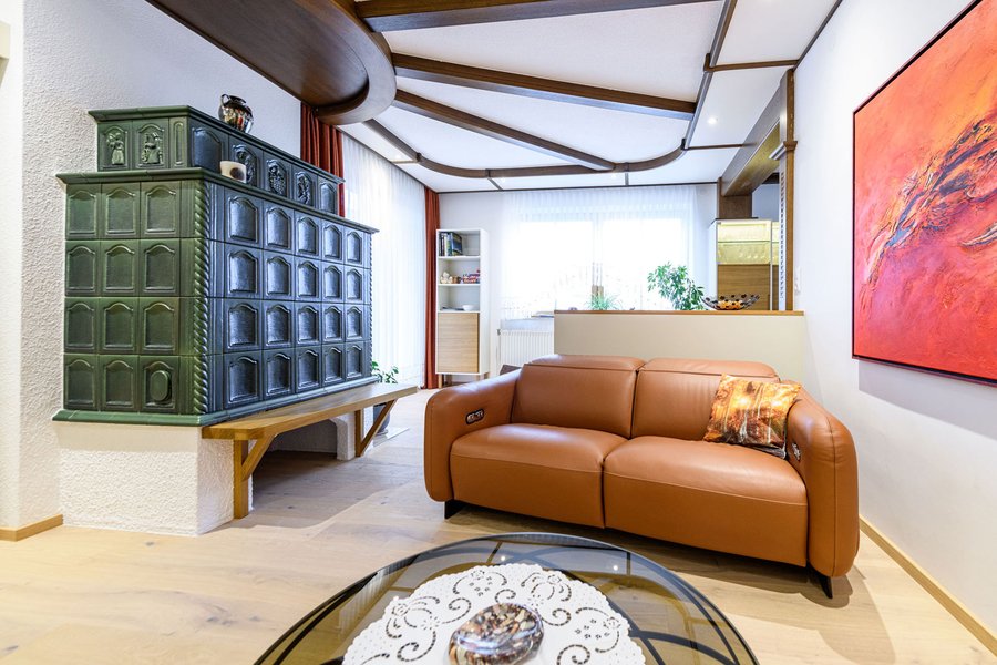 © Wolfgang Stecher/grapple.at Wohnzimmer mit grünem Kachelofen, Ledercouch und rundem Couchtisch