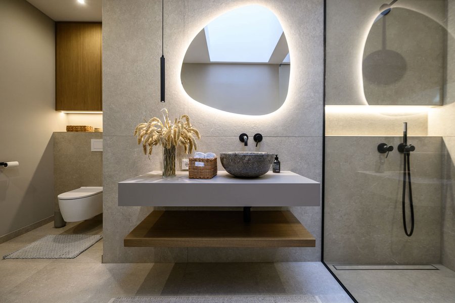 Badezimmer mit WC und moderner Dusche mit Glaswand und schwarzen Amaturen