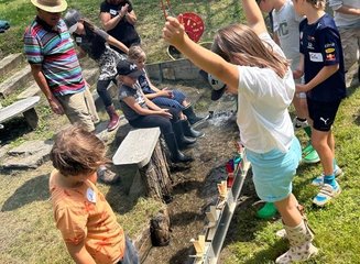 Wasserräder werden von Kindern in einem Bach getestet Ferienabenteuer in der Tischlerei