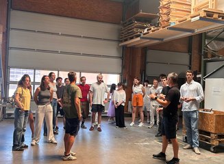 Schüler:innen bei der Besichtigung einer Tischlerei Besuch vom Kolleg für Innenarchitektur