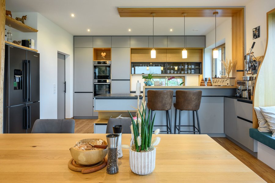 © Wolfgang Stecher/grapple.at Wohnküche mit integrierter Bar, großem Kühlschrank und einem Esstisch