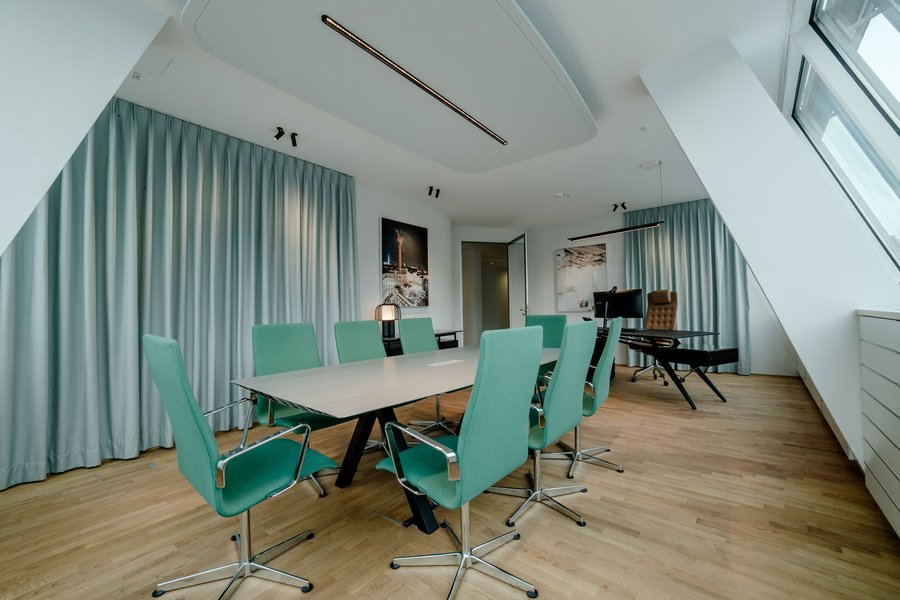 © Bureau EA Büro mit einem großen Tisch und Sesseln rund um den Tisch für Besprechungen.