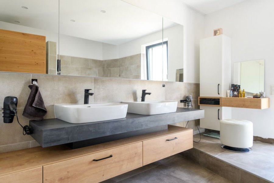 Badezimmer in grau und braun mit zwei Waschbecken