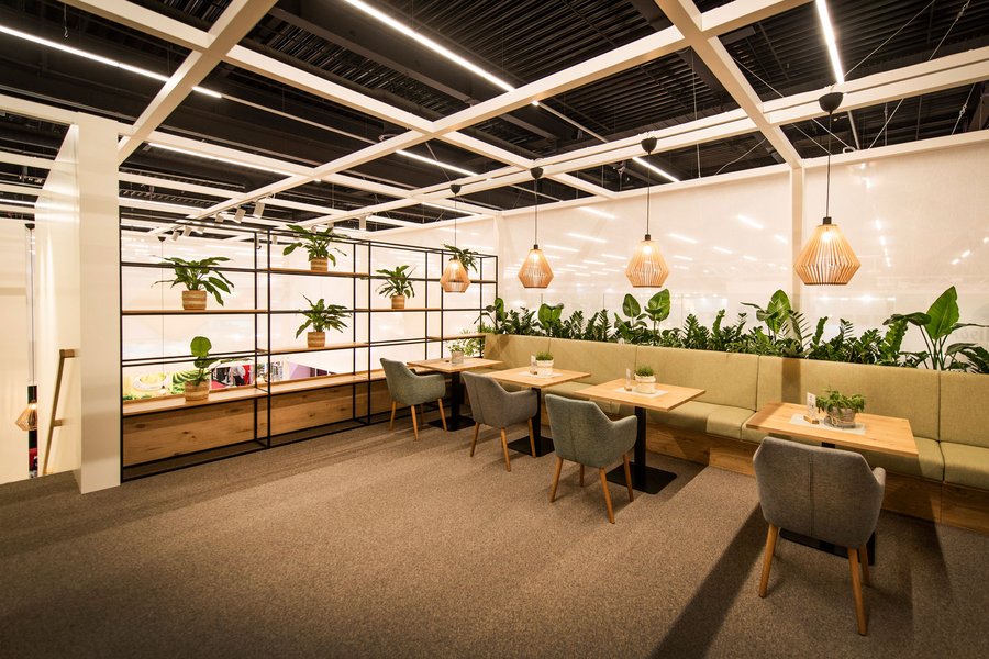 © Stefan Knittl Innenraum eines Messestandes mit Tischen und Sesseln