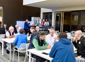Gäste die gemeinsam auf der Terrasse sitzen Grenzenloser Architektenabend