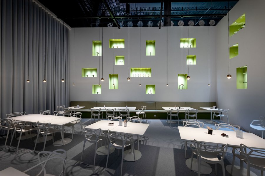 © Kim Culetto Sitzbereich für Gäste mit Tischen und Sesseln in weiß