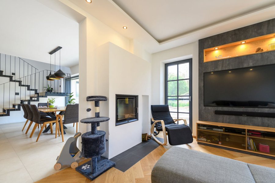 Wohnzimmer mit Ofen und Couch mit Blick in die Wohnküche