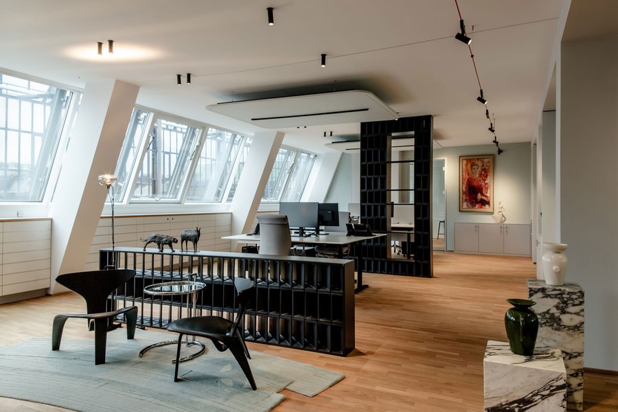 © Bureau EA Büro mit zwei Schreibtischen, welche durch schwarze Trennwände von einander abgegrenzt sind. Vor den Schreibtischen steht ein kleiner Tisch mit zwei Sesseln.