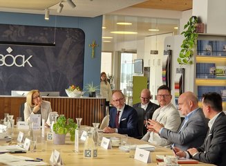 Dialog über Wirtschaft und Arbeit mit zahlreichen Personen auf einem großen Tisch "Wirtschaft und Arbeit im Dialog" zu Gast