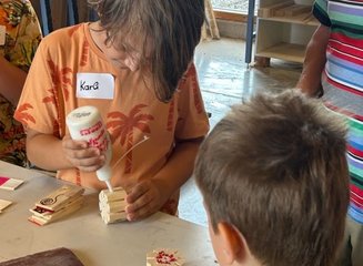 Kind klebt Wasserrad aus Holz zusammen Ferienabenteuer in der Tischlerei