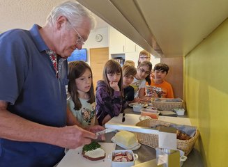Kinder und Seniorchef bei der gemeinsamen Essenszubereitung Volksschule Gerersdorf zu Besuch