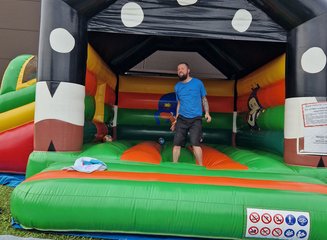 Mitarbeiter hüpft in der Hüpfburg Sommerfest 2025