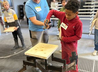 Kind beim Lackieren von Holz Handwerklicher Besuch der Volksschule Hafnerbach