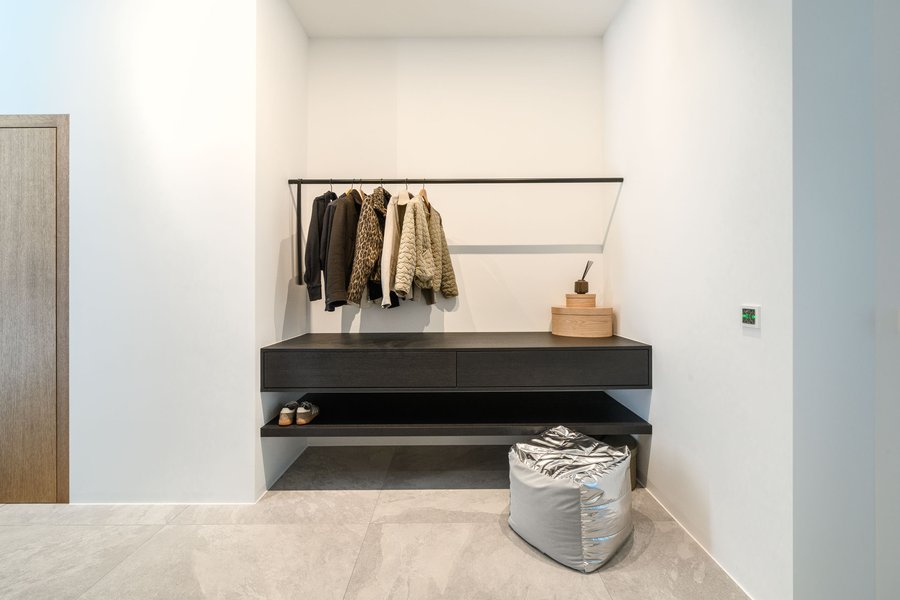 © Wolfgang Stecher/grapple.at Moderne Garderobe mit Kleiderstange und großen dunklen Holschränken.