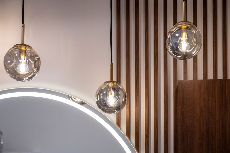 © Wolfgang Stecher/grapple.at Ausschnitt aus einem Badezimmer mit Spiegel, Hängeleuchten und Lamellenverbau