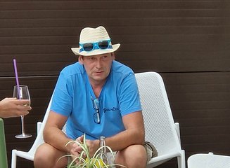 Mitarbeiter der Tischlerei mit Hut sitzt in einem Sessel auf der Terrasse Sommerfest 2025
