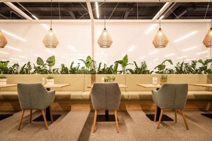 © Stefan Knittl Innenraum eines Messestandes mit Tischen und Sesseln