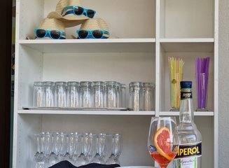 Regal mit Gläsern und Sommerhüten Sommerfest 2025