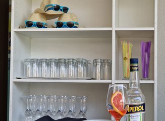 Regal mit Gläsern und Sommerhüten Sommerfest 2025