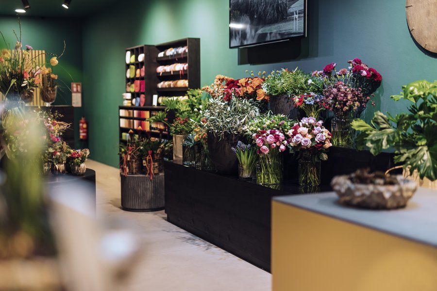 Regal mit unterschiedlichen Schnittblumen in Vasen