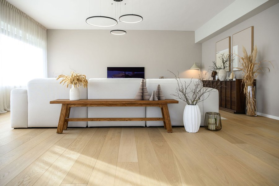 Wohnbereich mit Holzboden, weißem Sofa, natürlicher deko und alter Holzbank
